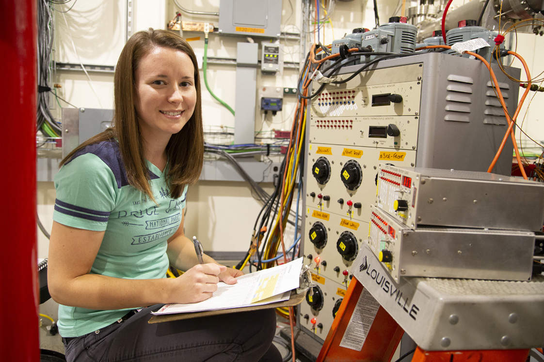 Katie Moring inspecting machinery at the Cornell high Energy Synchrotron Source.