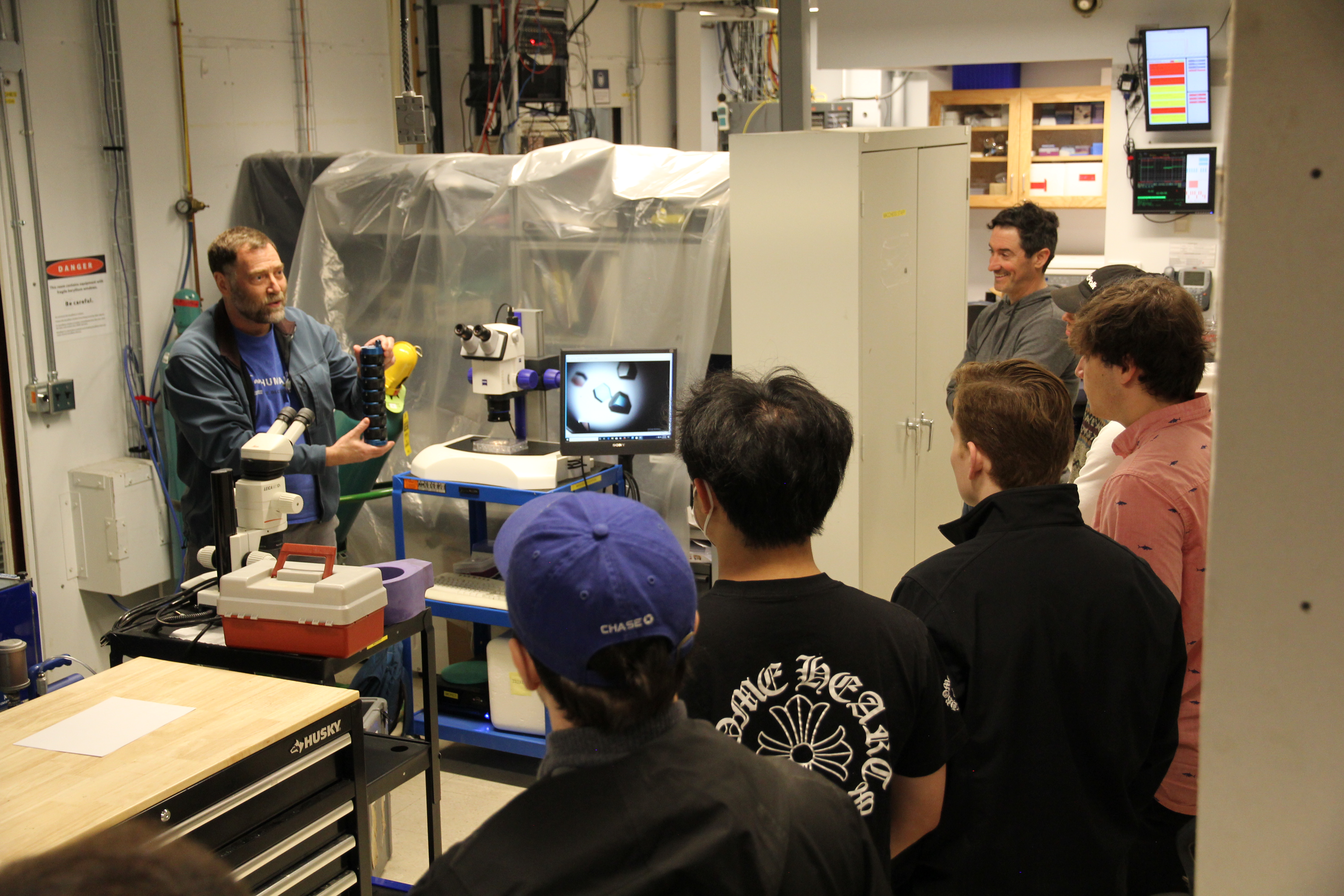 David Schuller shows students how biological samples are packed to be loaded into experimental stations.