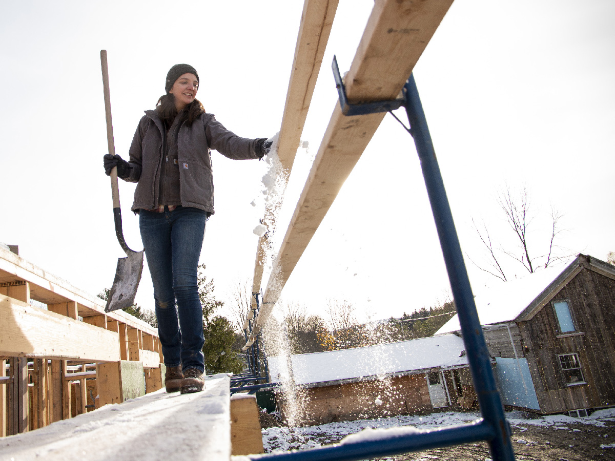 Elisabeth clears off snow from scaffolding for Habitat for Humanity