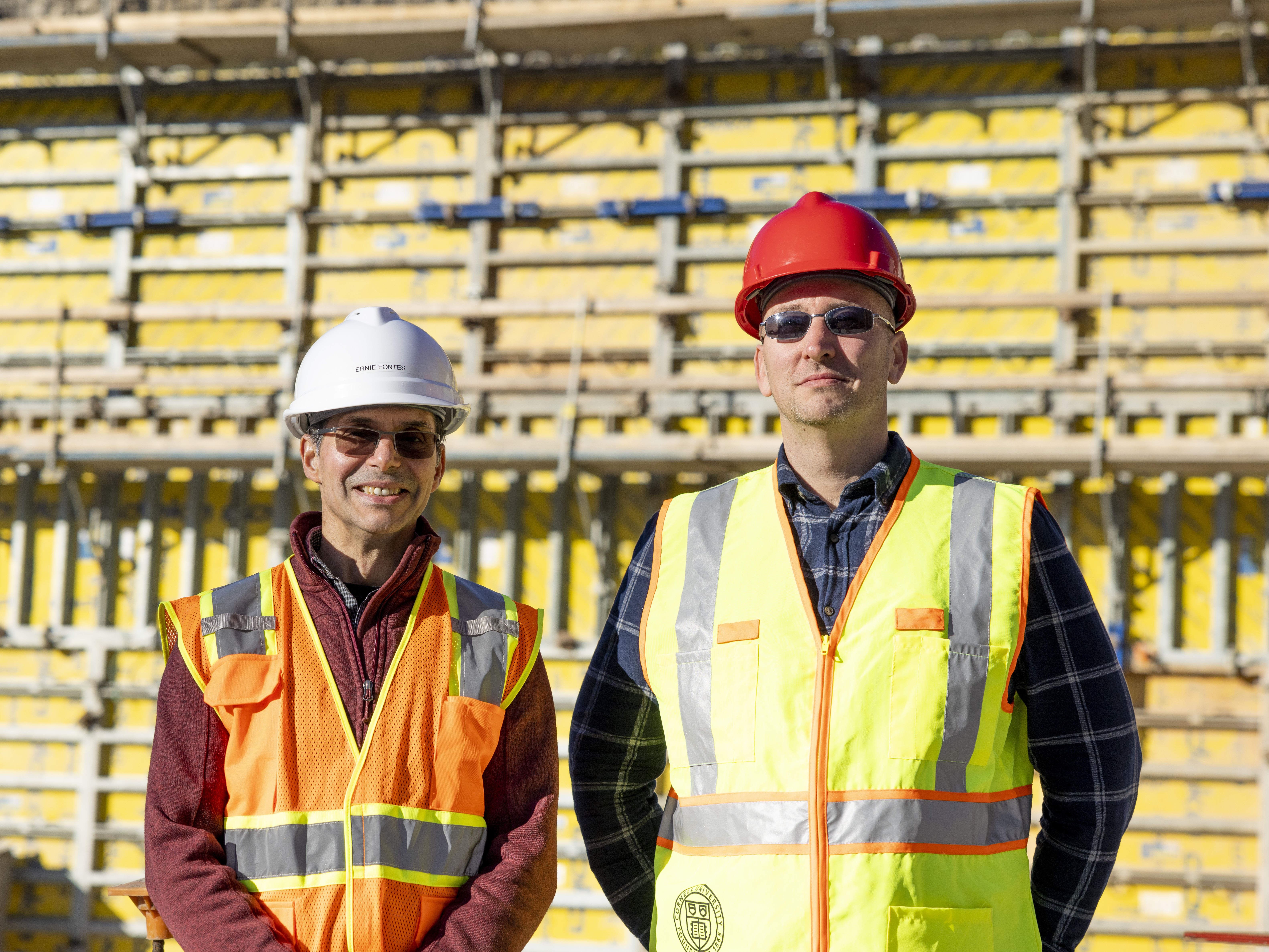 Image of two people in front of a wall being built