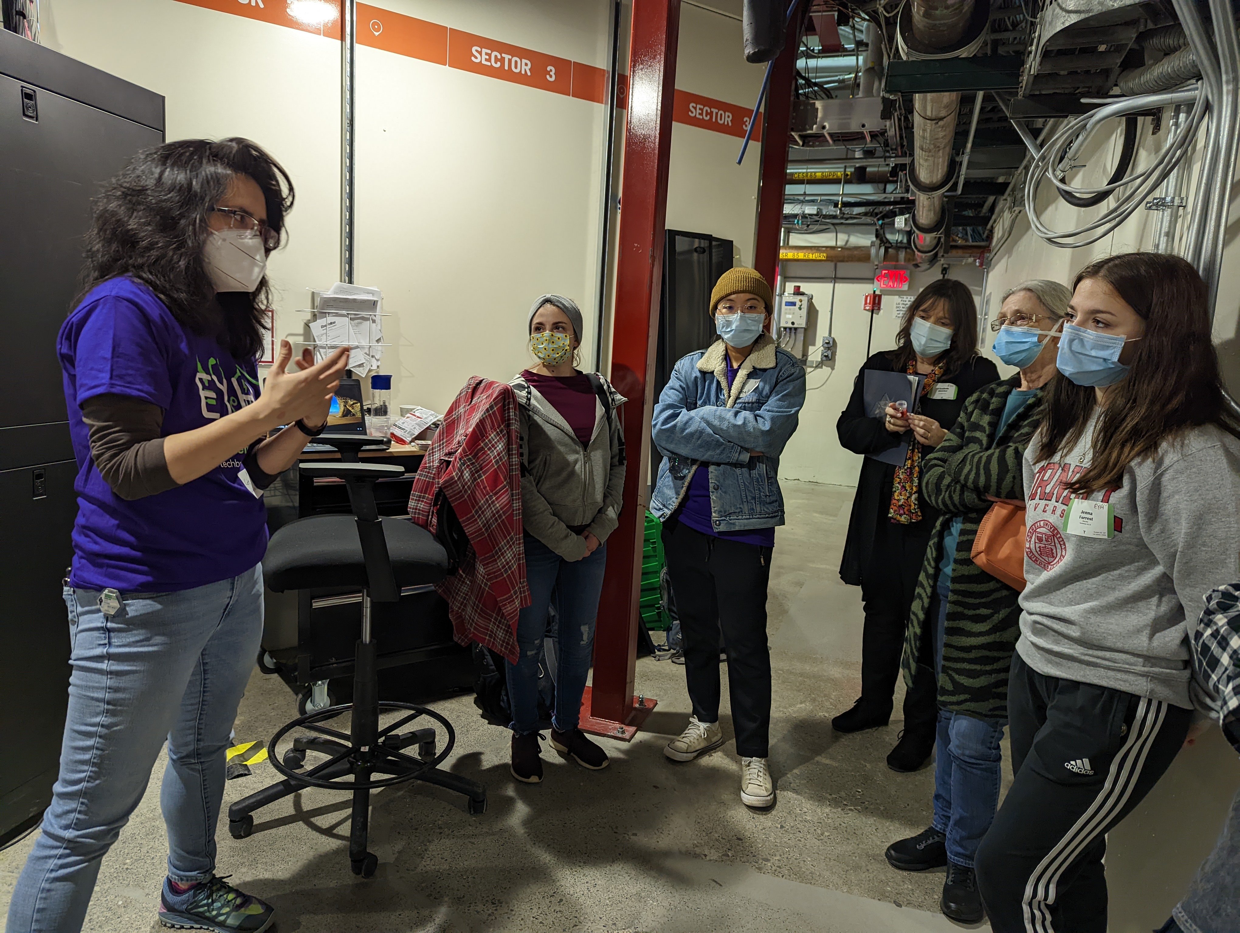 image of a staff scientist talking to students during a tour