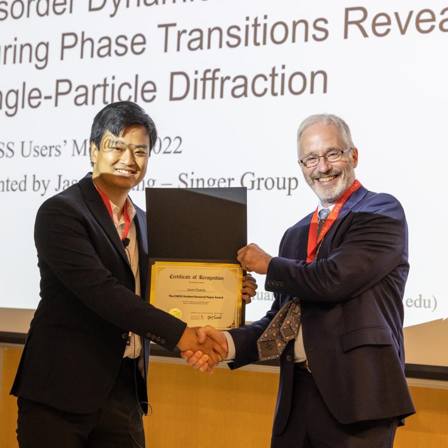 image of two people shaking hands and holding a certificate