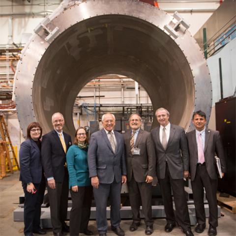 image of people standing in front of a metal tunnel