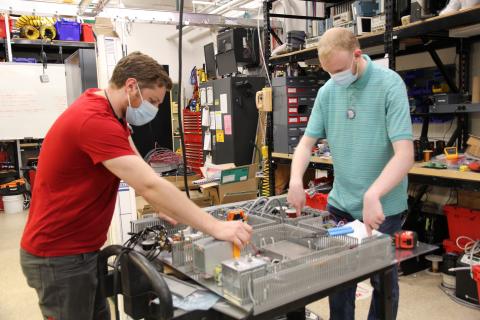 image of two people wearing masks working on a project