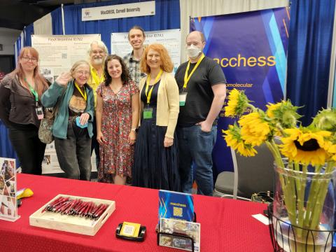 Image of seven people standing at a conference booth