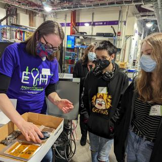 image of a scientist showing students research samples