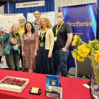 Image of seven people standing at a conference booth