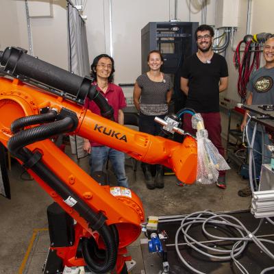 image of people standing behind a Kuka robot