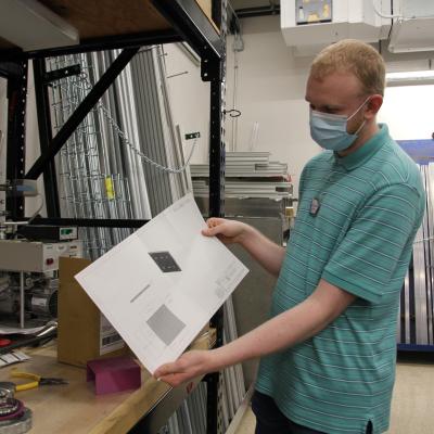 image of a person holding a printed out schematic