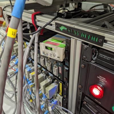 Image of a rack containing electronics. A label on the front reads "SUNY Delhi"