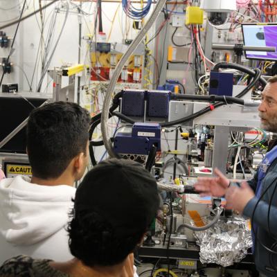 David Schuller shows beamline hardware to students at a macchess beamline