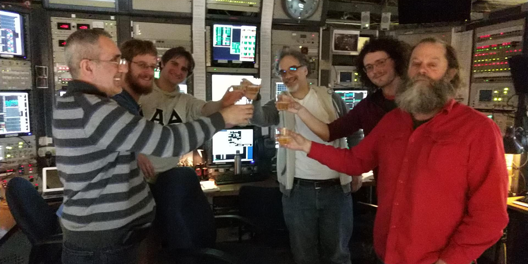 Team celebrates first turn of positrons on March 6, 2019